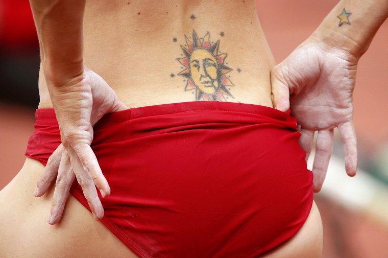 Image: The tattoos of Becky Holliday of the U.S. are seen as she competes in her women's pole vault Group B qualification at the London 2012 Olympic Games